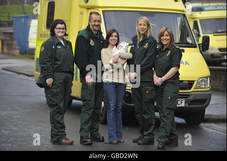 Cordelia Nolan, 25, mit ihrem 12 Wochen alten Baby Emrys und den Sanitätern und Hilfskanteln, die Frau Nolan dabei halfen, das Leben ihres Babys viermal in 10 Minuten zu retten. Stockfoto