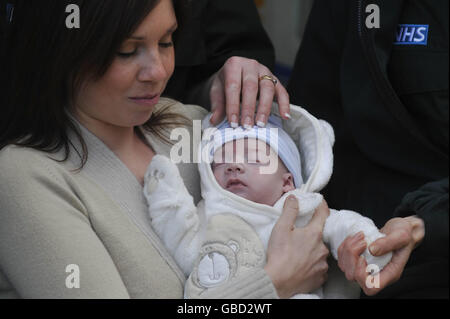 Cordelia Nolan, 25, mit ihrem 12 Wochen alten Baby Emrys und den Sanitätern und Hilfskanteln, die Frau Nolan dabei halfen, das Leben ihres Babys viermal in 10 Minuten zu retten. Stockfoto