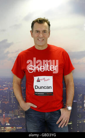 Duncan Bannatyne steht vor einem Foto von Londons Skyline ganz oben auf dem Tower 42 in der City of London, als er Vertical Rush startet, Ein Ausdauerereignis, das die Menschen herausfordert, die Treppe des Turms in der schnellsten Zeit zu laufen, um Geld für die Wohnungsbauhilfe Shelter zu sammeln. Stockfoto