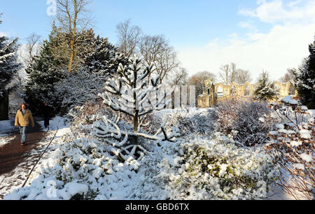 Besucher genießen einen Spaziergang durch die schneebedeckten Museumsgärten in York, da der Schnee weite Teile des Landes bedeckt. Stockfoto