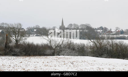 Die Houghton Kirche ist am Horizont über schneebedeckte Felder entlang der Uppingham Road (A47) zwischen Bushby und Houghton on the Hill, Leicestershire, zu sehen. Stockfoto