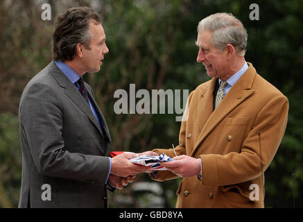 Der Prinz von Wales überreicht dem Direktor des Catlin Arctic Survey Teams Pen Hadlow bei einem Abschiedsempfang für das Catlin Arctic Survey Team im Clarence House, London, einen Wimpel. Stockfoto