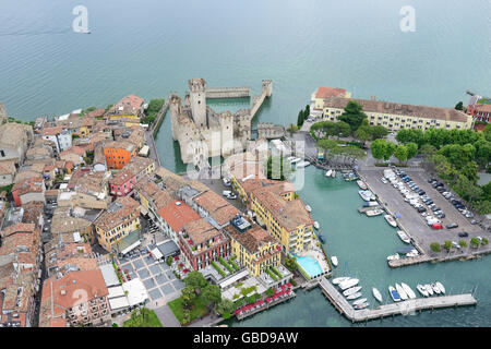 LUFTAUFNAHME. Mittelalterliche Burg in einer einzigartigen 'aquatischen' Umgebung am Ufer des Gardasees. Halbinsel Sirmione, Provinz Brescia, Lombardei, Italien. Stockfoto