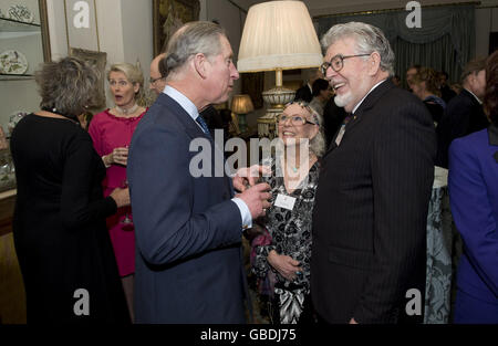 Der Prinz von Wales, Schirmherr des in Großbritannien ansässigen Royal Flying Doctor Service of Australia (RFDS), spricht mit Rolf Harris und seiner Frau Alwen während eines Empfangs, um Unterstützer des RFDS im Clarence House in London zu würdigen. Stockfoto