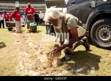 Ein Platzwart gräbt die Run-ups, nachdem das Spiel während des zweiten Tests auf dem Sir Vivian Richards Cricket Ground in Antigua aufgegeben wurde. Stockfoto