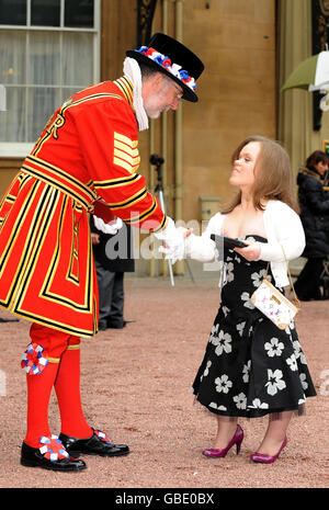 Yeoman Sergeant Roderick Truelove, die eine Royal Victorian Medal erhielt, gratuliert der Paralympischen Schwimmerin Eleanor Simmonds, nachdem sie ihren MBE von der britischen Königin Elizabeth II. Im Buckingham Palace, London, erhalten hat. Stockfoto