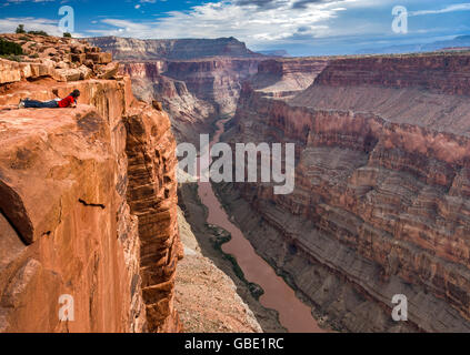 Zwei junge Männer, die mit Blick auf den Grand Canyon aus Toroweap Point am North Rim, 1000 Meter über dem Colorado River, Arizona, USA Stockfoto