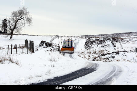 Ein Grinter grät eine schneebedeckte Straße in Perthshire. Stockfoto