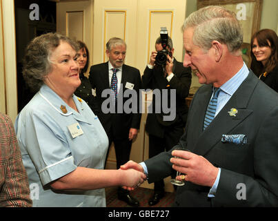 Der Prinz von Wales schüttelt sich die Hände mit der Krankenschwester Ann Brady aus Worcestershire während eines Empfangs für die Marie Curie Cancer Care, deren Patron er ist, im Clarence House im Zentrum von London. Stockfoto