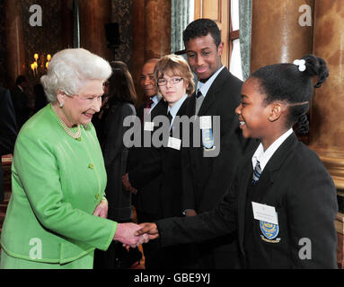 Die britische Königin Elizabeth II. Schüttelt die Hände mit Sinae Prendergast von der Kingbury High School, beobachtet von Schulfreunden Hashi Ahmed (zweite rechts) und Fergus Leahy (dritte rechts), nachdem sie heute Nachmittag die Monarchy-Website im Buckingham Palace im Zentrum von London neu gestartet hat. Stockfoto