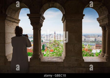 Frau unter Foto, ein Tourist in einem Kloster in der fishermens Bastion in Budapest Fotos des Parlaments über die Stadt. Stockfoto