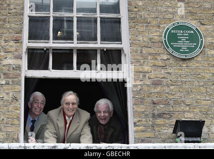 Der Komiker Barry Cryer (rechts), der Fernsehmoderator Nicholas Parsons (Mitte) und der Komiker Jo Goodman (links) am Fenster des Geländes in der Greek Street, Soho, wo Peter Cooks Establishment Club heute mit der Enthüllung einer grünen Westminster-Plakette im Zentrum von London gedenkt wurde. Stockfoto