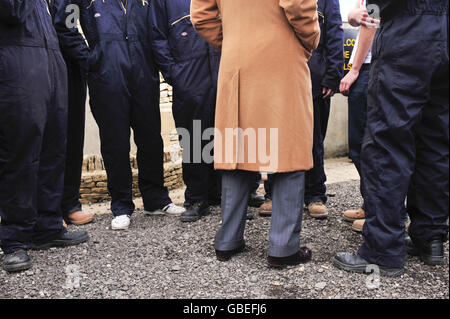 Die Füße des Prinzen von Wales (Mitte) sind unter denen der Schweißpraktikanten im Rural Skills Center in Cirencester, Gloucestershire zu sehen. Stockfoto