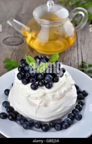 Pavlova Kuchen mit Heidelbeeren mit Minze dekoriert Stockfoto