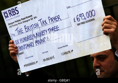 Ein nationaler Zeitungsjournalist hält heute vor dem Haus von Sir Fred Goodwin in Edinburgh einen gefälschten Scheck. Gordon Brown äußerte heute seine "Wut" über die 693,000-Jahresrente, die dem ehemaligen Chef der Royal Bank of Scotland Sir Fred Goodwin zugesprochen wurde, die der Premierminister als "nicht zu rechtfertigen und inakzeptabel" bezeichnete. Stockfoto