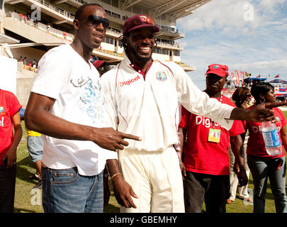 West Indies Kapitän Chris Gayle mit dem jamaikanischen Athleten Usain Bolt (links) beim ersten Test im Sabina Park, Kingston, Jamaika. Stockfoto