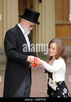 Der Autor Sir Terry Pratchett zeigt seine Ritterschaft gegenüber der Paralympischen Schwimmerin Eleanor Simmonds, die ihm wiederum ihren MBE zeigt, nachdem sie von der britischen Königin Elizabeth II. Im Buckingham Palace, London, ausgezeichnet wurden. Stockfoto