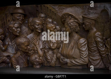 Nahaufnahme eines von zwei Bronzereliefs, die zeigen, dass die Königin Mutter während des Blitzes Familien besucht, die von Bomben obdachlos gemacht wurden, und die Rennen in Ascot genießt. Die Schnitzereien wurden in die Seiten eines Denkmals für die Königin Mutter eingearbeitet, das heute in der Mall im Zentrum von London enthüllt wurde. Stockfoto