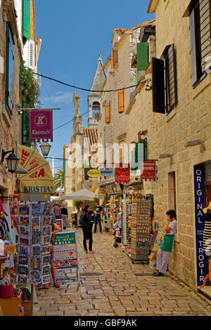 Alte Gasse & Souvenir Geschäfte hinter der Uferpromenade von Trogir, Kroatien Stockfoto