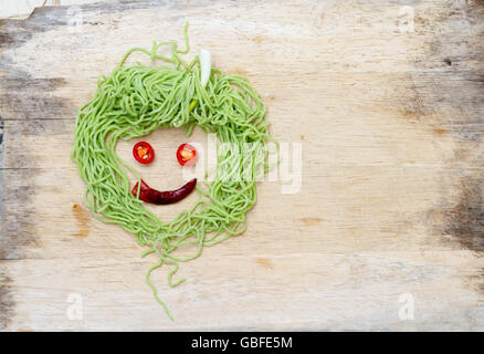 Smiley-Gesicht auf Holz hergestellt aus Gemüse und Nudeln Stockfoto