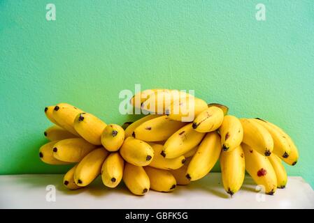 Bündel von Lady Finger Bananen liegen auf einem Regal Stockfoto