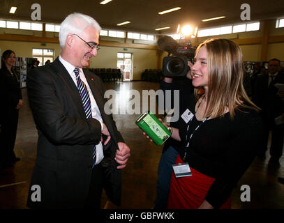 Bundeskanzlerin Alistair Darling legt Geld für Comic-Hilfe in eine Sammelbox, die der Tanzlehrer des P.E. Departments Jo Emery während eines Besuchs der Millais School in Horsham, West Sussex, im Vorfeld des G20-Finanztreffens am Wochenende in der Grafschaft gehalten hat. Stockfoto
