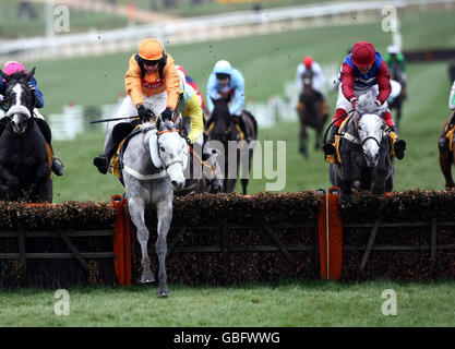 Zaynar mit Barry Geraghty (orangefarbene Kappe) führt den zweitplatzierten Walkon mit Robert Thornton (kastanienbraune Kappe) über die letzte Hürde in der JCB Triumph Hürde auf der Cheltenham Racecourse, Cheltenham. Stockfoto