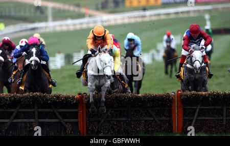 Zaynar mit Barry Geraghty (orangefarbene Kappe) führt den zweitplatzierten Walkon mit Robert Thornton (kastanienbraune Kappe) über die letzte Hürde in der JCB Triumph Hürde auf der Cheltenham Racecourse, Cheltenham. Stockfoto