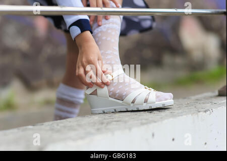 kleines Mädchen auf ihre Sandalen im freien Stockfoto