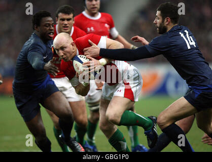 Tom Shanklin (Mitte) aus Wales bricht beim RBS 6 Nations-Spiel im Stade de France in Paris zwischen dem französischen Fulgence Ouedraogo (links) und Julien Malzieu durch. Stockfoto