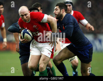 Tom Shanklin (Mitte) aus Wales bricht beim RBS 6 Nations-Spiel im Stade de France in Paris zwischen dem französischen Fulgence Ouedraogo (links) und Julien Malzieu. Stockfoto