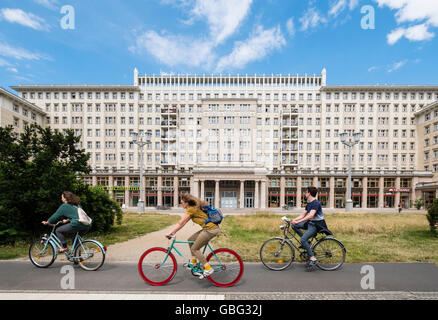 Radfahrer fahren vorbei an historischen sozialistischen ehemaligen DDR Mehrfamilienhäuser auf der Karl-Marx-Allee in Berlin Deutschland Stockfoto