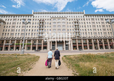 Zwei Frauen in Führungspositionen zu Fuß in Richtung der historischen sozialistischen ehemaligen DDR Mehrfamilienhäuser auf der Karl-Marx-Allee in Berlin Deutschland Stockfoto