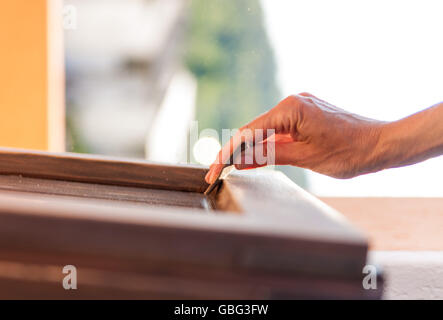 Hände einer Frau mit Sandpapier tun DIY arbeiten auf hölzernen Befestigungen Stockfoto