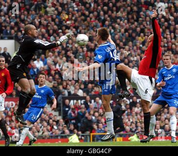 Manchester United Torhüter Tim Howard pariert den Ball klar als Chelseas Jesper Gronkjaer schließt sich an Stockfoto