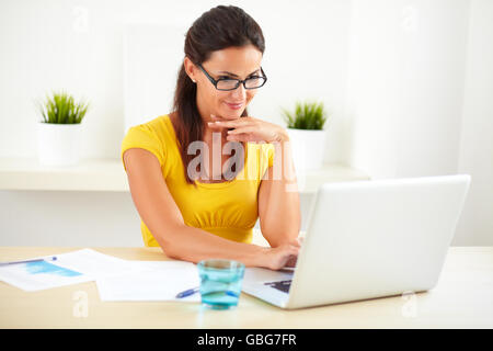 Ziemlich lateinischen Rezeptionistin mit Brille arbeiten auf den Kundendienst in ihrem Arbeitsplatz Stockfoto