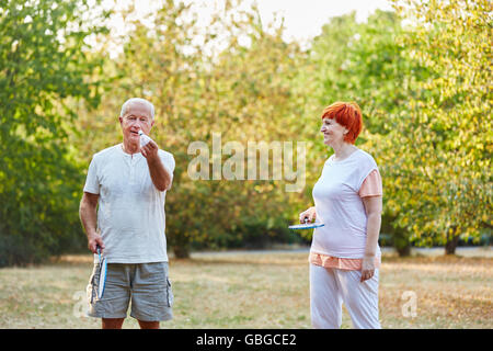 Älteres paar Badminton im Park im Garten spielen Stockfoto