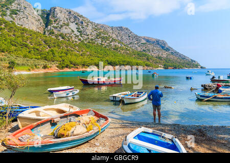 Fischer, stehend unter Angelboote/Fischerboote am einsamen Strand, Insel Samos, Griechenland Stockfoto