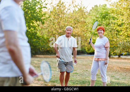 Gruppe von Senioren spielen Badminton im Park im Sommer Stockfoto