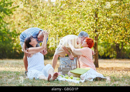 Glückliche ältere Paare machen ein Picknick im Sommer im park Stockfoto
