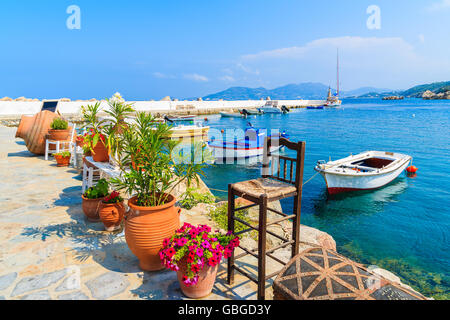 Blume Töpfe auf und Anzeigen der Angelboote/Fischerboote ankern in Kokkari Bucht, Insel Samos, Griechenland Stockfoto