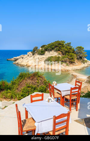 Tische mit Stühlen in typisch griechische Taverne in Kokkari Bucht, Insel Samos, Griechenland Stockfoto