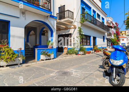 Straße mit bunten Häusern und Roller geparkt auf Seite in Kokkari Stadt, Insel Samos, Griechenland Stockfoto