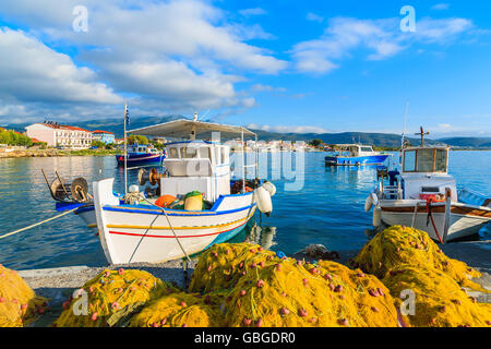 Fischernetze im Vordergrund und griechischen Angelboote/Fischerboote festmachen im Hafen bei Sonnenaufgang auf die Insel Samos, Griechenland Stockfoto