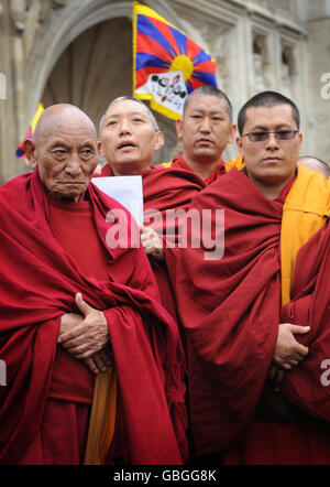 Buddhistische Mönche beten heute, nachdem sie vor der Westminster Abbey in London einen Kranz an der Gedenkstätte für unschuldige Opfer niedergelegt haben, um den 50. Jahrestag des Aufstands des tibetischen Volkes gegen die Besetzung Tibets durch China zu begehen. Stockfoto