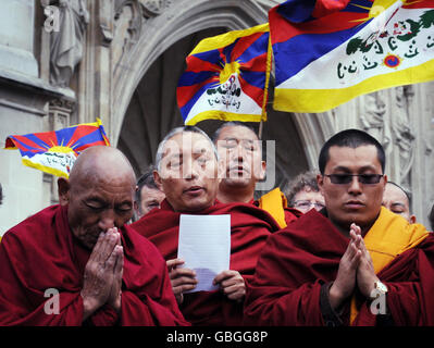 Buddhistische Mönche beten heute, nachdem sie vor der Westminster Abbey in London einen Kranz an der Gedenkstätte für unschuldige Opfer niedergelegt haben, um den 50. Jahrestag des Aufstands des tibetischen Volkes gegen die Besetzung Tibets durch China zu begehen. Stockfoto