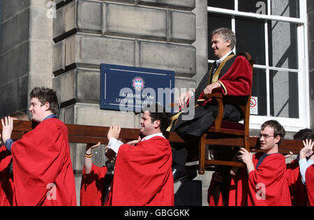 Der Rektor der New Edinburgh University, Iain Macwhirter, wird nach seiner Installationszeremonie auf einem Sedan-Stuhl um das Old College getragen. Stockfoto