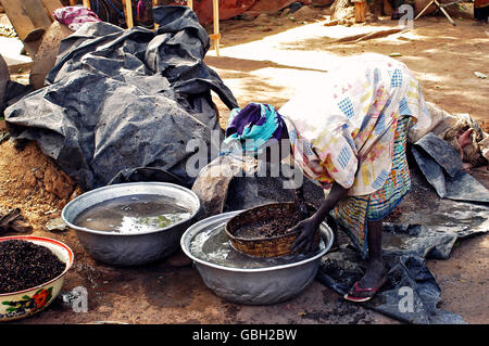 eine alte Frau, die kochen lokale Bier aus Hirse in Burkina Faso genannt Dolo mitten auf einer Straße in Bobo-Dioulasso Stockfoto