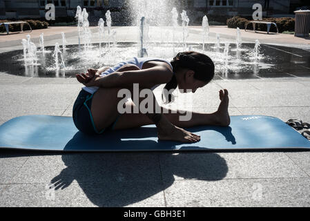 Frau im Stadtpark Yoga zu praktizieren. Stockfoto