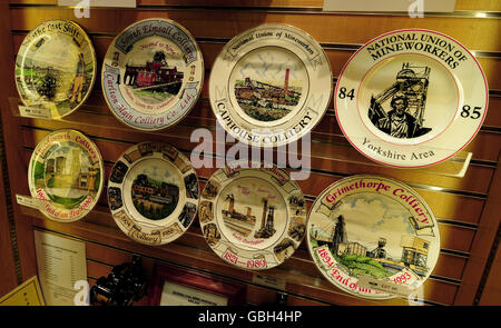 Gedenkplatten zur Geschichte des Kohlebergbaus, zum Verkauf im National Mining Museum in Caphouse Colliery in der Nähe von Wakefield. Eine neue Tafel zum 25. Jahrestag des Bergarbeiterstreiks, die diesen Monat vor 25 Jahren begann (oben rechts), zeigt unter anderem Gruben, die nach dem einjährigen Streit geschlossen wurden. Stockfoto